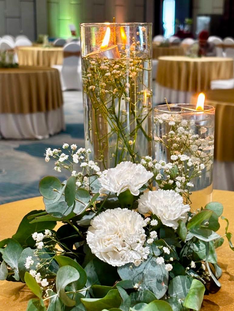 Floating candles and white carnations dinner centerpiece