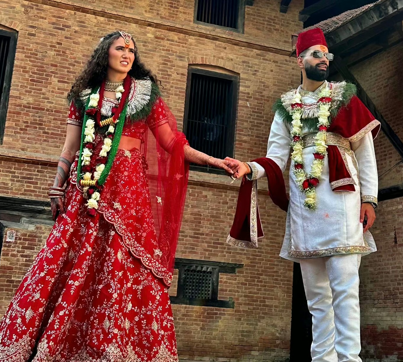 A beautiful international couple exchanging vows in a traditional Nepali setting.
