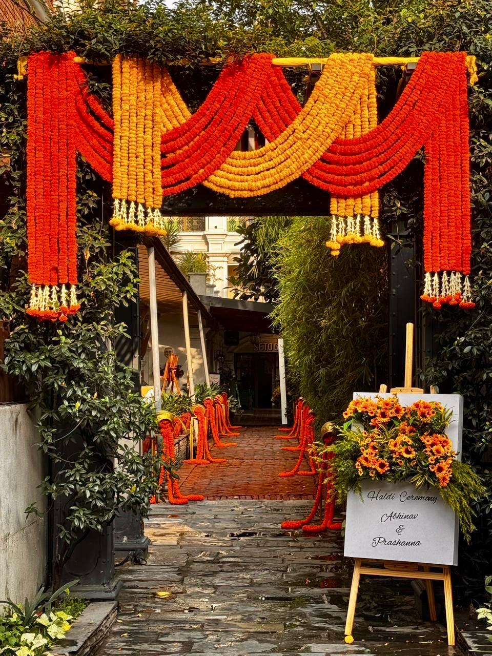 Haldi ceremony entrance decorated with orange marigold garlands